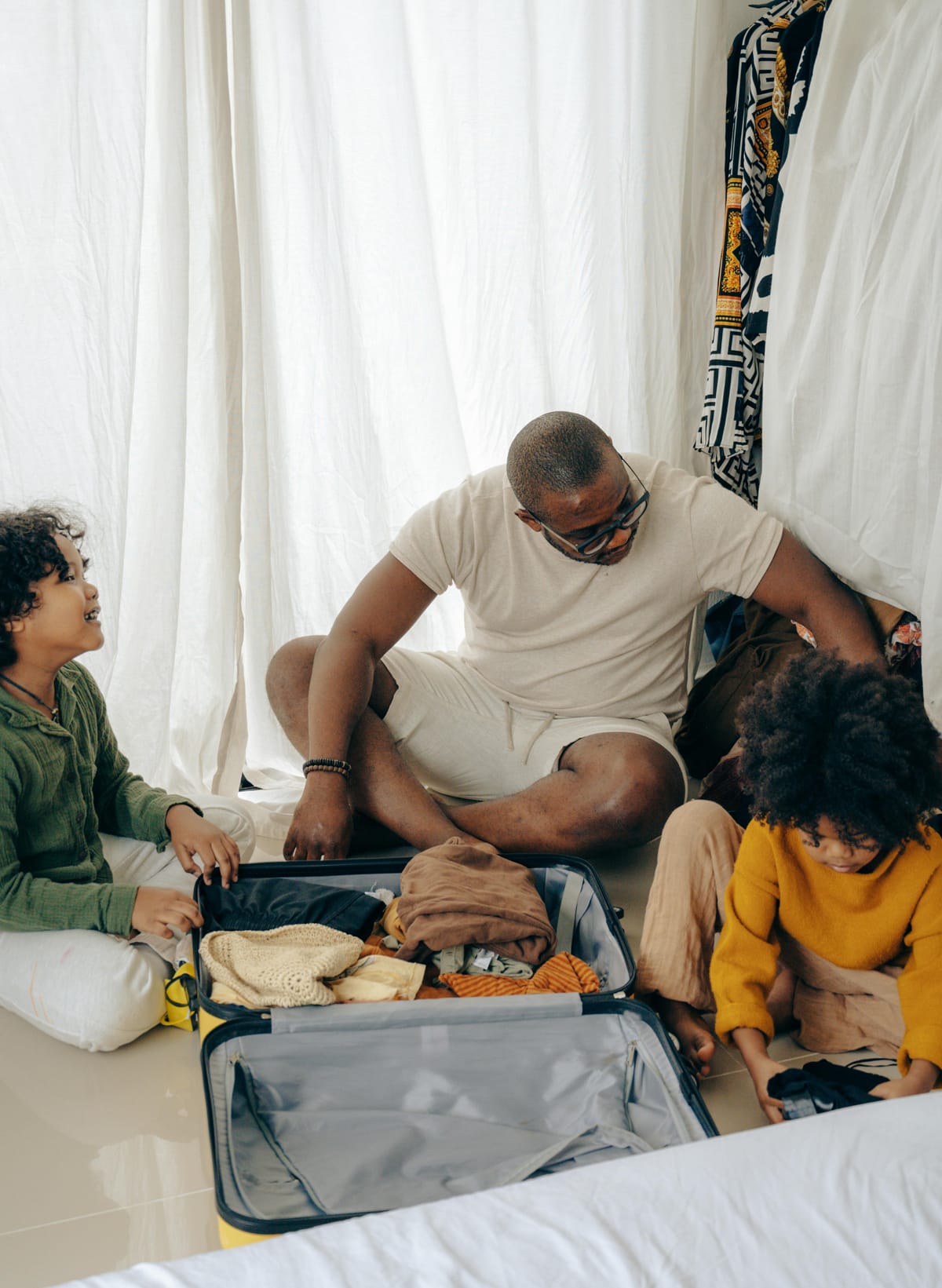 Dad and two kids packing a suitcase
