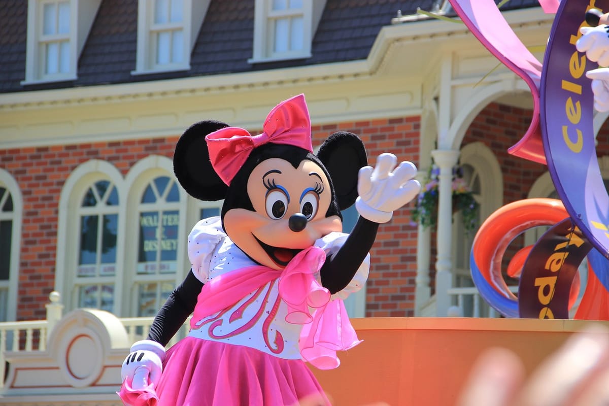 Minnie Mouse character greeting guests at Disney World with her signature red polka dot dress and bow